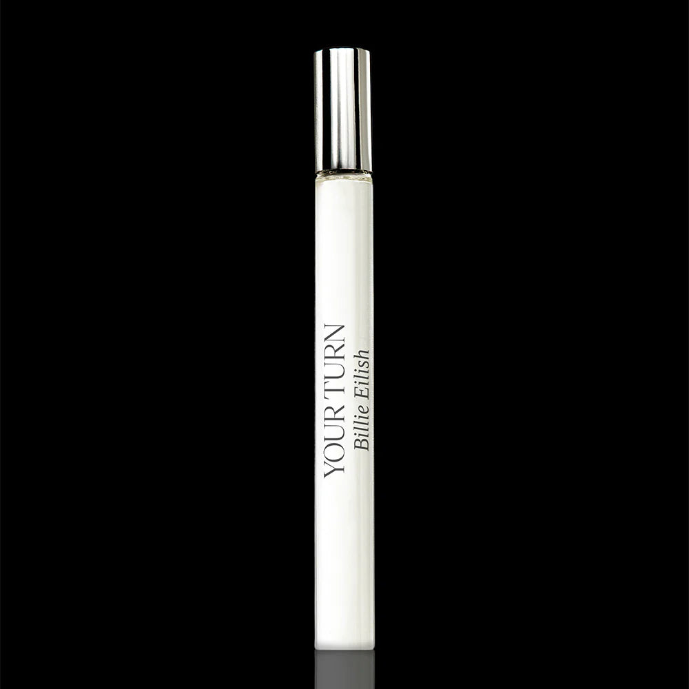 White cylindrical lip balm tube with silver cap and "Your Turn Billie Eilish" branding on black background.